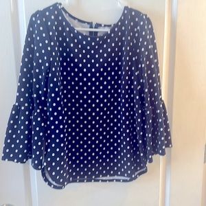 Blue form fitting top with white polka dots, zipper detail in back,flowy sleeves